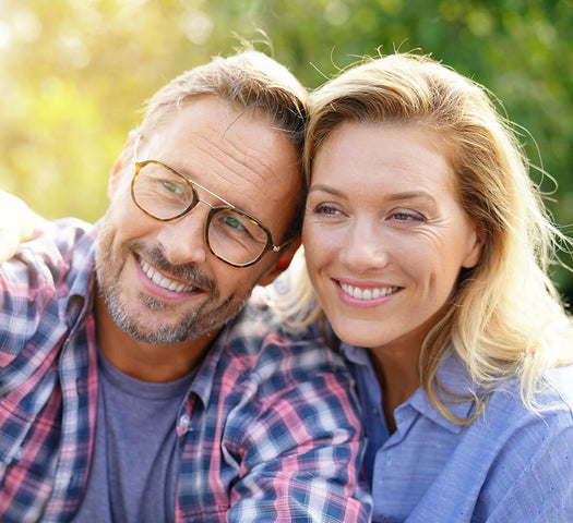 Older man with beard and glasses and older lasy with blonde taking a selfie
